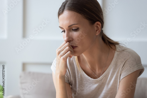 Upset young woman feel depressed thinking at home