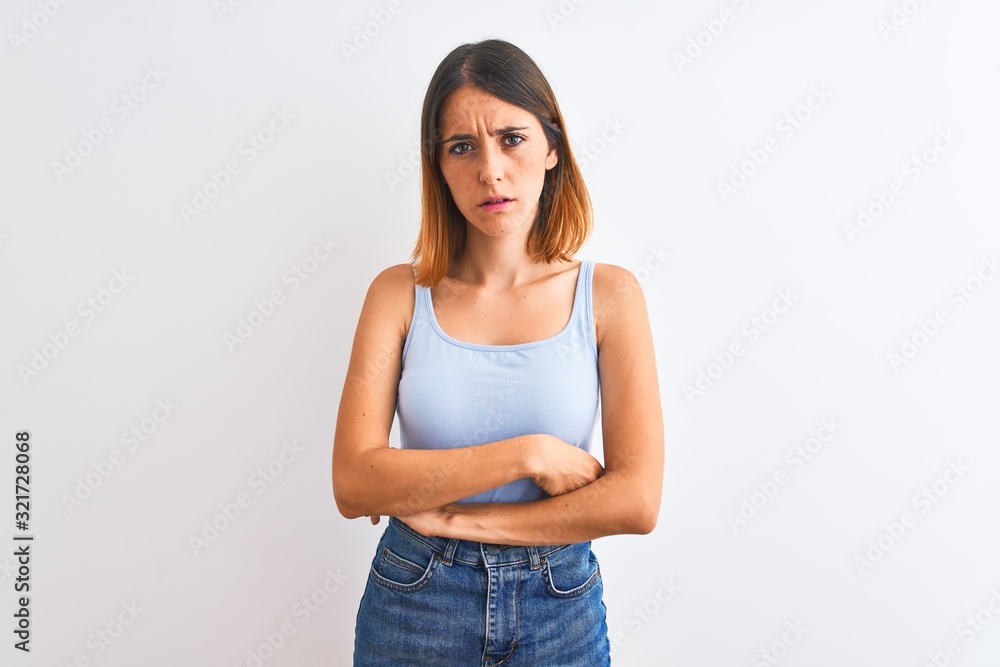 Beautiful redhead woman standing over isolated background skeptic and nervous, disapproving expression on face with crossed arms. Negative person. Beautiful redhead woman standing over isolated background skeptic and nervous, disapproving expression on face with crossed arms. Negative person.