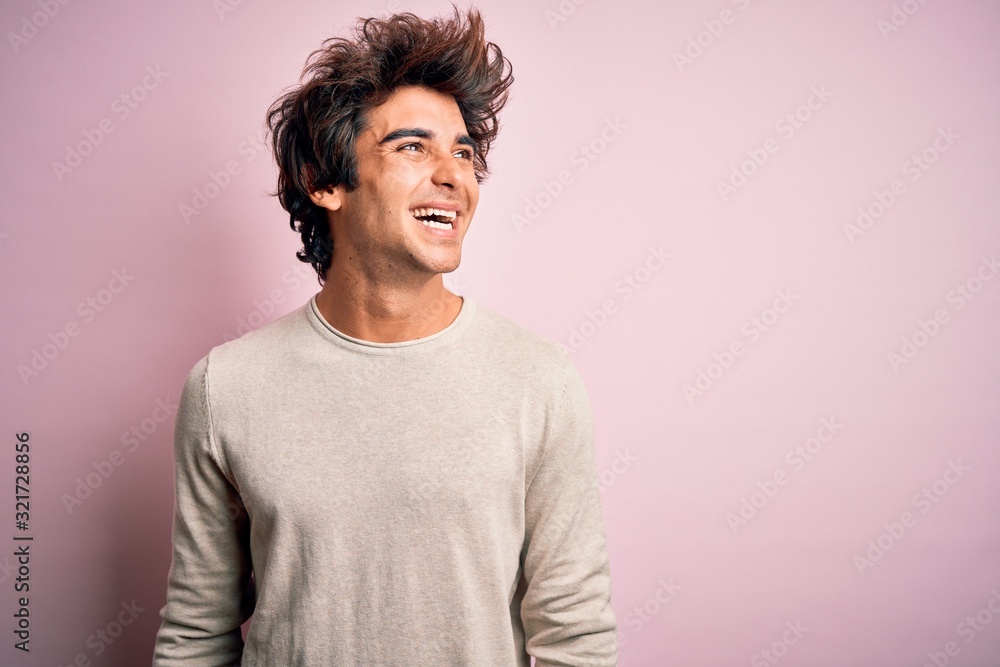 Young handsome man wearing casual t-shirt standing over isolated pink background looking away to side with smile on face, natural expression. Laughing confident. Young handsome man wearing casual t-shirt standing over isolated pink background looking away to side with smile on face, natural expression. Laughing confident.