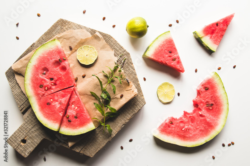 watermelon on a sliced board with mint and slices of lime. food