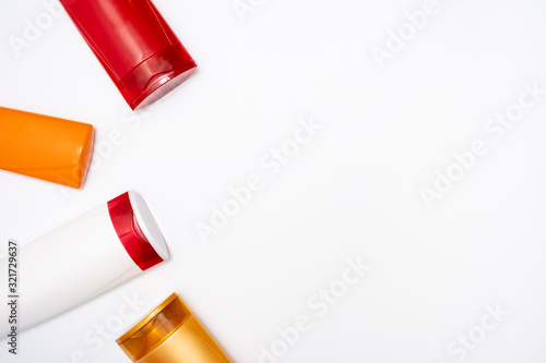 Colorful plastic shampoo and hair conditioner bottles close up on white background, copy space