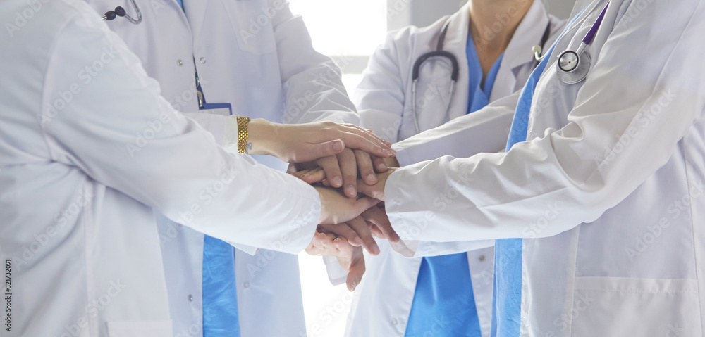 Team of medical workers holding hands together indoors, above view. Unity concept Team of medical workers holding hands together indoors, above view. Unity concept