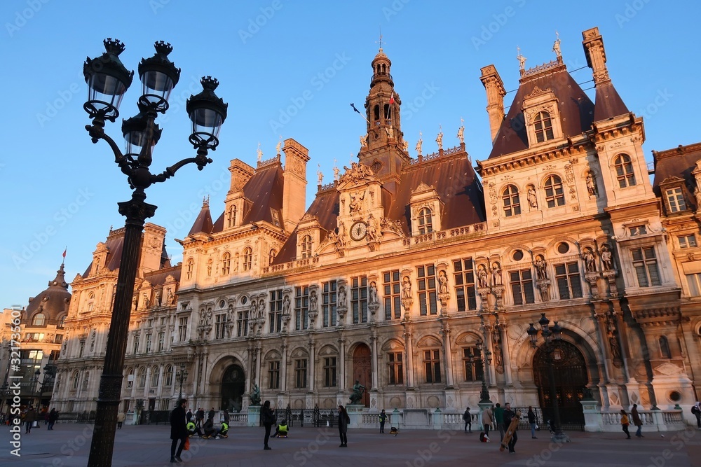 Hôtel de ville / mairie de Paris, façade au soleil couchant avec un réverbère (France)