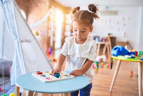 Young beautiful toddler learning mathematics playing with maths game at kindergaten photo