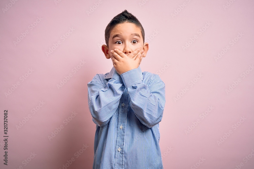 Young little boy kid wearing elegant shirt standing over pink isolated background shocked covering mouth with hands for mistake. Secret concept. Young little boy kid wearing elegant shirt standing over pink isolated background shocked covering mouth with hands for mistake. Secret concept.