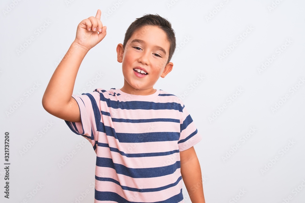 Beautiful kid boy wearing casual striped t-shirt standing over isolated white background pointing finger up with successful idea. Exited and happy. Number one. Beautiful kid boy wearing casual striped t-shirt standing over isolated white background pointing finger up with successful idea. Exited and happy. Number one.