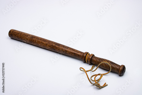 Schilderij op canvas Wooden Night Stick with leather strap on white background