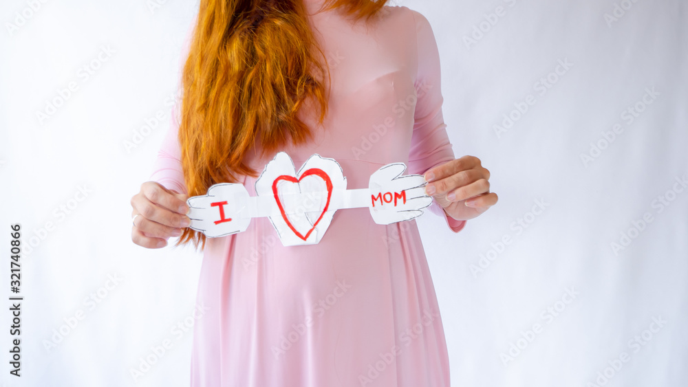 A pregnant woman is holding a heart in her hands A pregnant woman is holding a heart in her hands