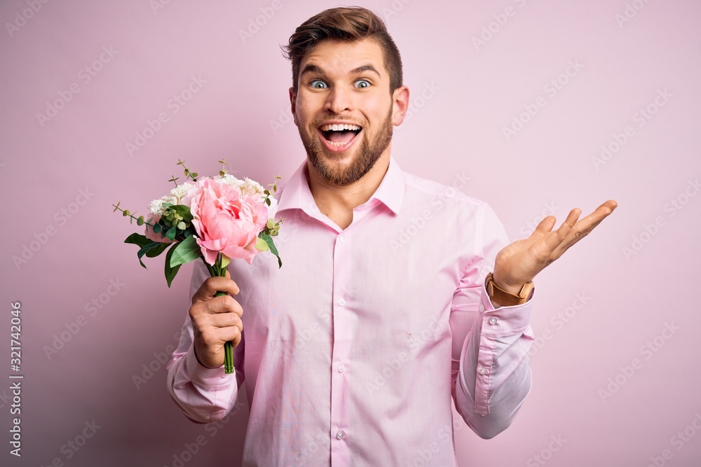 Young blond romantic man with beard and blue eyes holding beautiful bouquet of flowers very happy and excited, winner expression celebrating victory screaming with big smile and raised hands Young blond romantic man with beard and blue eyes holding beautiful bouquet of flowers very happy and excited, winner expression celebrating victory screaming with big smile and raised hands