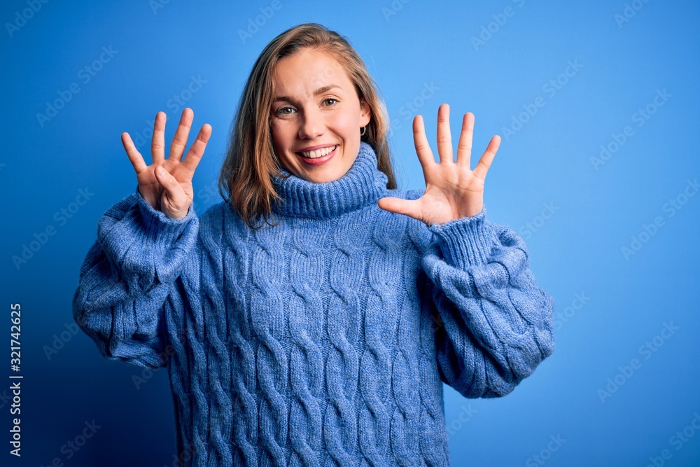 Young beautiful blonde woman wearing casual turtleneck sweater over blue background showing and pointing up with fingers number nine while smiling confident and happy. Young beautiful blonde woman wearing casual turtleneck sweater over blue background showing and pointing up with fingers number nine while smiling confident and happy.
