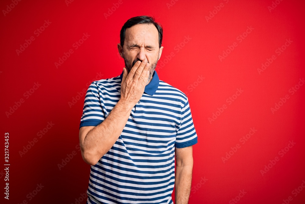 Middle age hoary man wearing casual striped polo standing over isolated red background bored yawning tired covering mouth with hand. Restless and sleepiness. Middle age hoary man wearing casual striped polo standing over isolated red background bored yawning tired covering mouth with hand. Restless and sleepiness.