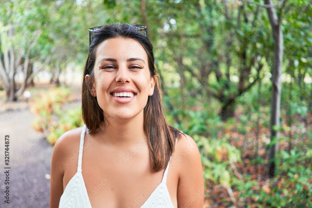 Young beatiful woman smiling happy and cheerful at green park on a sunny day of summer Young beatiful woman smiling happy and cheerful at green park on a sunny day of summer