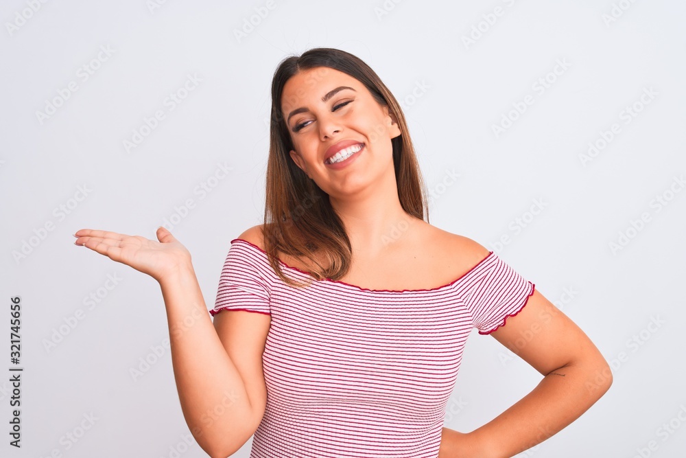 Portrait of beautiful young woman standing over isolated white background smiling cheerful presenting and pointing with palm of hand looking at the camera. Portrait of beautiful young woman standing over isolated white background smiling cheerful presenting and pointing with palm of hand looking at the camera.