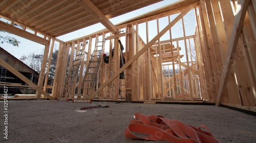 Timelapse of framer attaching beams with hydraylic hammer at frame house building