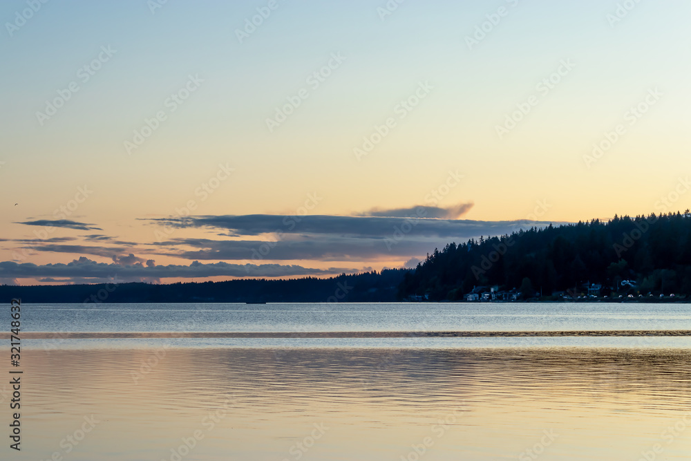 bright evening color over clouds and land near shoreline bright evening color over clouds and land near shoreline