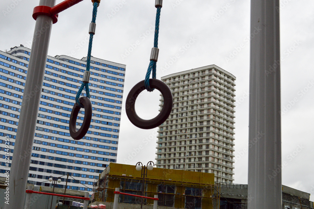Sports rings on the street under the open sky for sports against the background of the house in the new district of the city in the courtyard of the new building