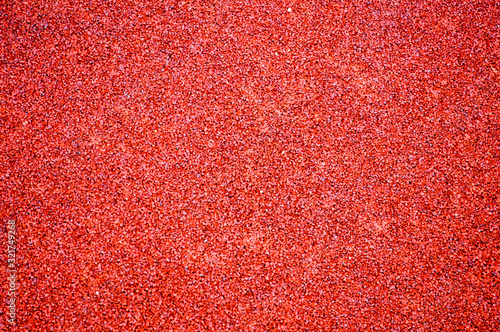 Red bright soft rubber flooring safe for sports and workout or on the playground from the many small round pebbles pressed. Background, texture