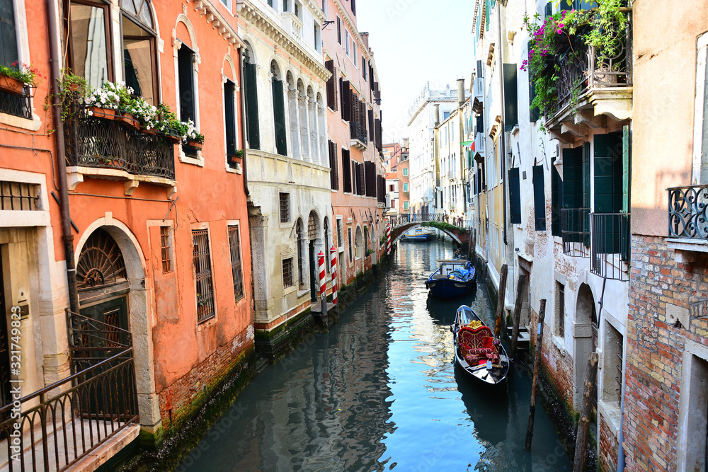 Traditional narrow canal street with gondola and colorful buildings, Venice, Italy