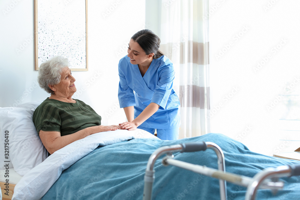 Obraz premium Care worker with elderly woman in geriatric hospice