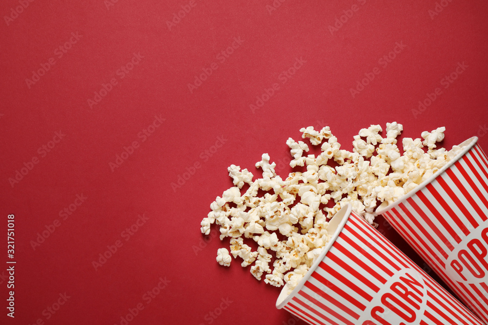 Flat lay composition with delicious popcorn on red background. Space for text Flat lay composition with delicious popcorn on red background. Space for text