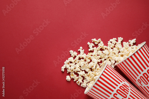 Flat lay composition with delicious popcorn on red background. Space for text