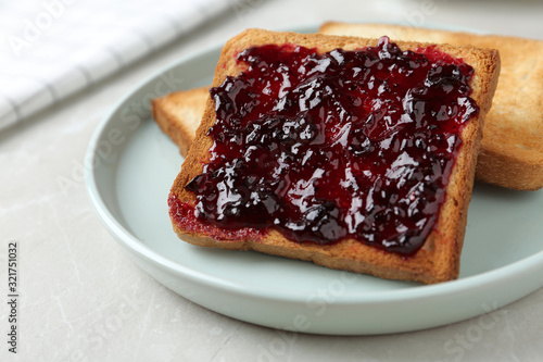 Delicious crispy toasts with jam on table, closeup