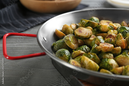 Delicious roasted brussels sprouts on grey wooden table, closeup
