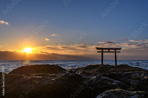 Oarai Japanese white shinto torii gate in the sea at sunrise