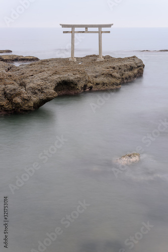 Oarai Japanese white shinto torii gate in a calm sea photo