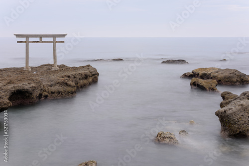 Oarai Japanese white shinto torii gate in a calm sea photo