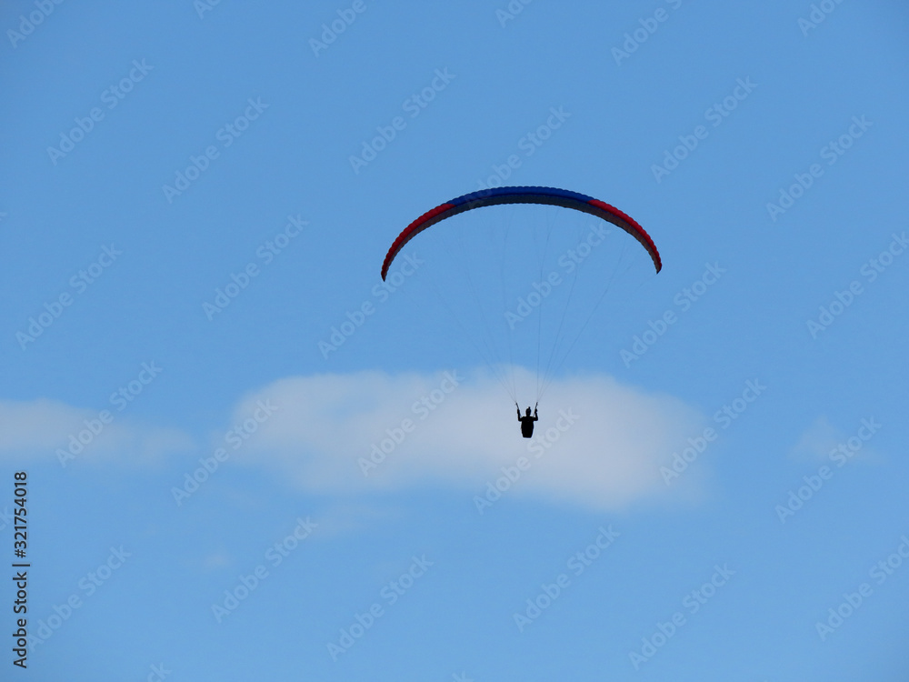 Paraglide flight in blue sky and some white clouds Paraglide flight in blue sky and some white clouds
