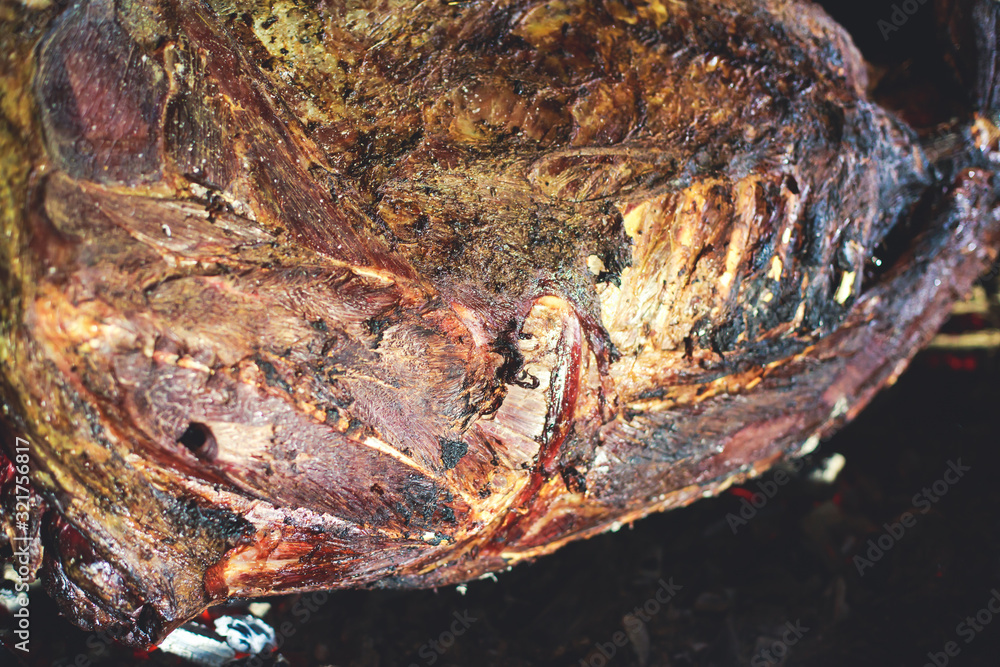 Fototapeta premium Different stages of cooking the steak on a kitchen, barbeque, roasted lamb ribs, big dish plate with roasted full pork head, served in restaurant with vegetables, lamb, ham and chicken.