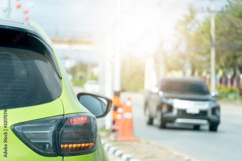 Fototapeta premium Luxury of green car stop on the asphalt junction by traffic light control in across. Traveling in the provinces during the bright period. Open light brake.