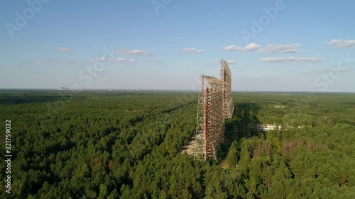 Aerial view of the DUGA radar station near the city of Chernobyl-2 among the forest. Exclusion Zone. Camera pans right. 4K drone footage. photo