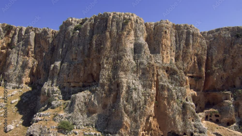 The beautiful rock formation of the Arbel cliff mountain in Israel - low aerial The beautiful rock formation of the Arbel cliff mountain in Israel - low aerial