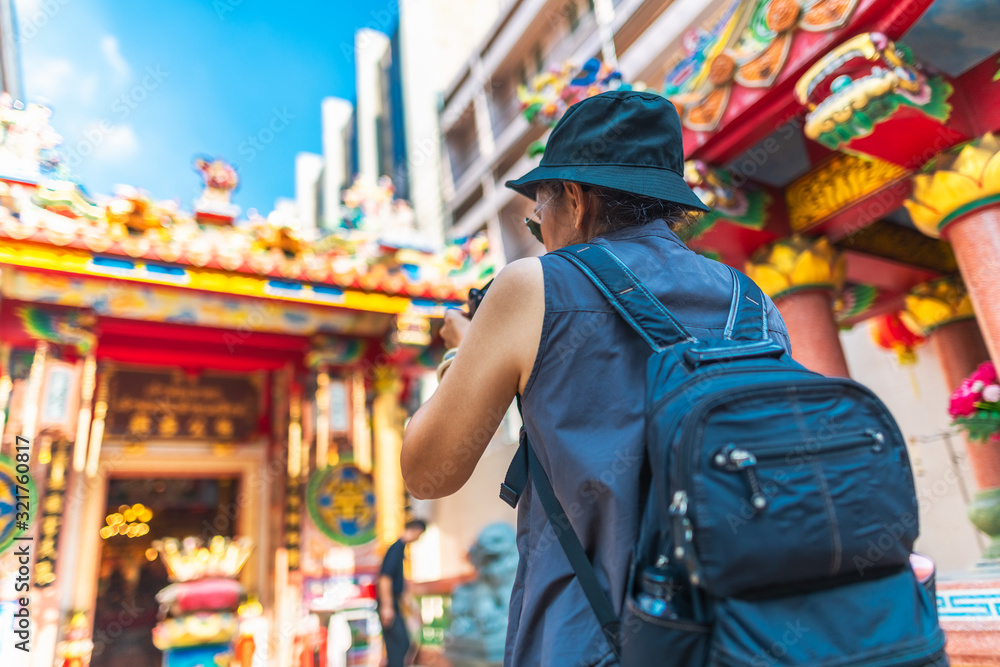 Obraz premium Traveler woman with backpack looking and taking photo Chinese shrine, Famous landmark travel Bangkok Thailand, Tourist female on summer holiday vacation trips, Tourism beautiful destination place Asia