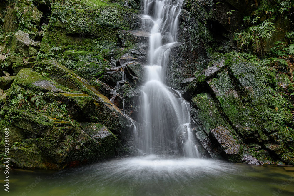 Waterfall with stones covered by moss in a forest (Uguisu's falls in Nara, Japan)