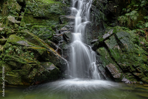 Fototapeta Naklejka Na Ścianę i Meble -  Waterfall with stones covered by moss in a forest (Uguisu's falls in Nara, Japan)