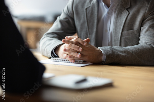 Papier peint Two businessmen with clasped hands sitting opposite close up