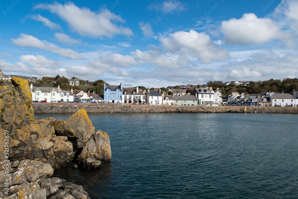 Looking at view of Portpatrick waterfront in Dumfries and Galloway in Scotland. Sunny day in autumn in the south west of Scotland. Scottish houses in seaside village.