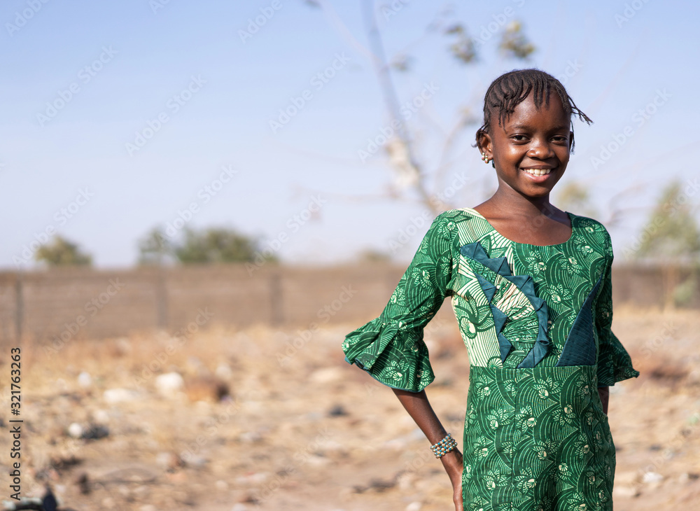  African black schoolgirl walking and posing with beautiful big eyes and looking at camera - obrazy, fototapety, plakaty 