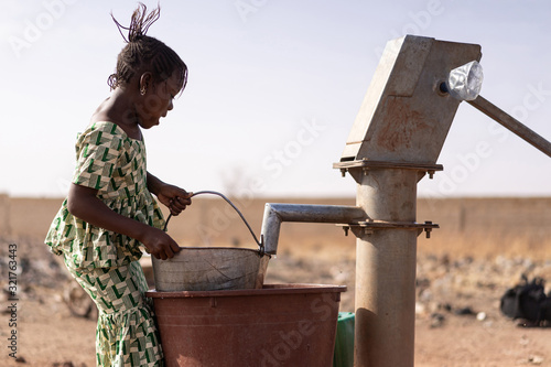 Joyful West African Girl Saving Healthy Water in a rural village