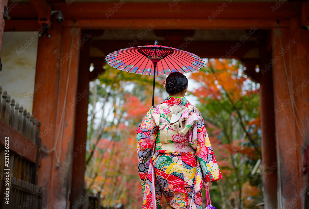 woman holding retro umbrella in old fashion style, wearing traditional or original Japanese dressed, walks in the middle of street of the village garden autumn park, travel and visit japan
