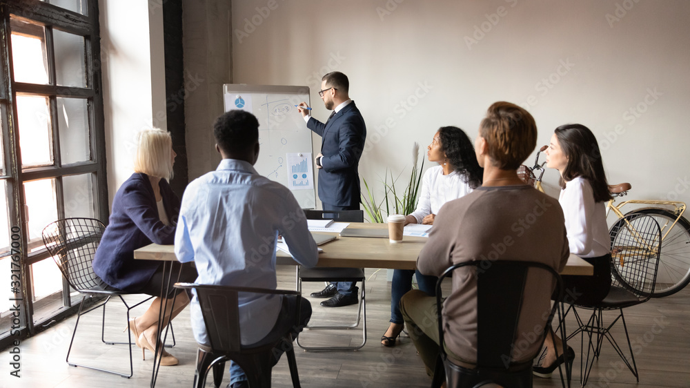 Boss presenting topic to multi-ethnic audience using flip chart Boss presenting topic to multi-ethnic audience using flip chart