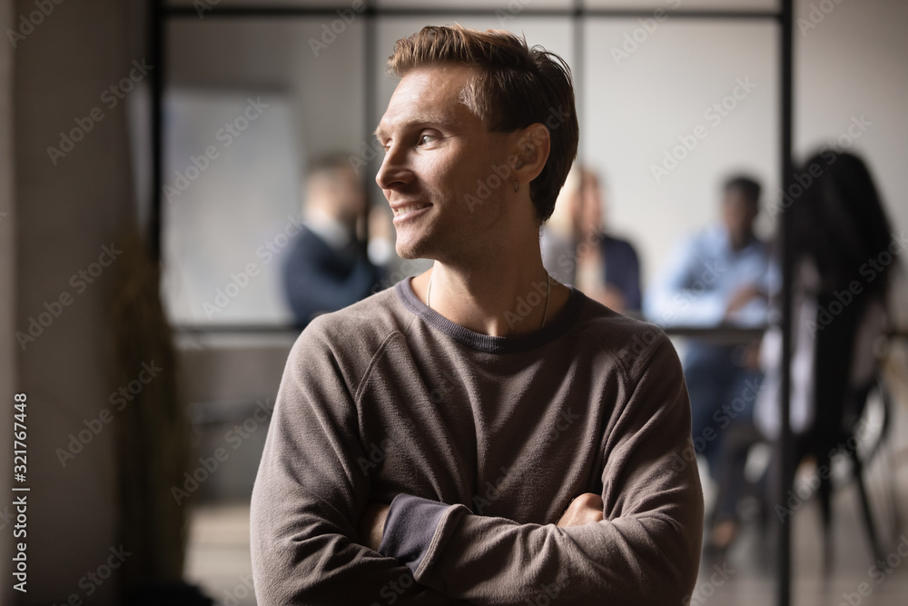 Millennial guy posing in office dreaming about career growth Millennial guy posing in office dreaming about career growth
