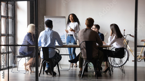 Diverse workers listening african businesswoman tell about strategy at meeting photo