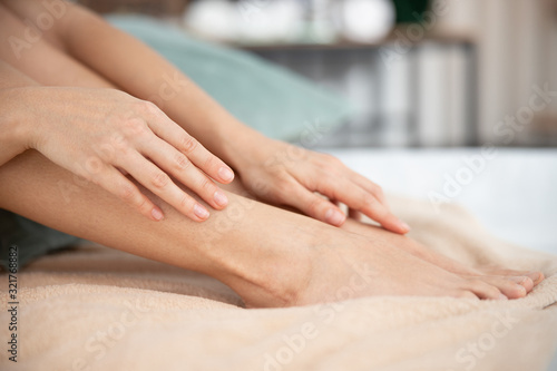 Young lady touching silky skin on her feet