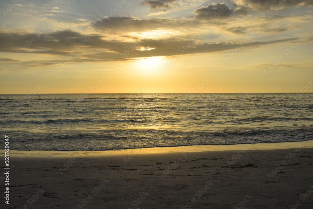 Golden sunset in ocean sea. Reflection golden sun rays in sea water in sunset.