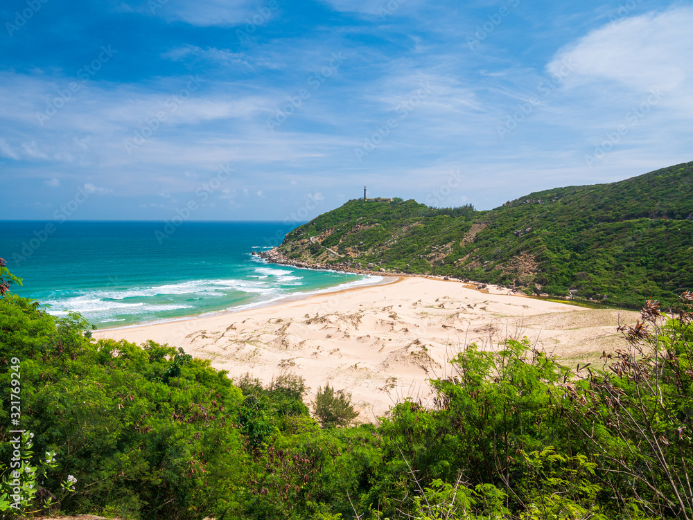 Expansive view of scenic tropical bay, Bai Mon gorgeous golden beach and sand dunes blue waving sea. The easternmost coast in Vietnam with lighthouse, Phu Yen province between Da Nang and Nha Trang.