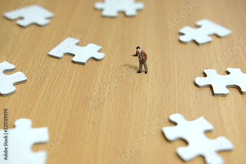 Business strategy conceptual photo - miniature businessman pointing on missing piece puzzle
